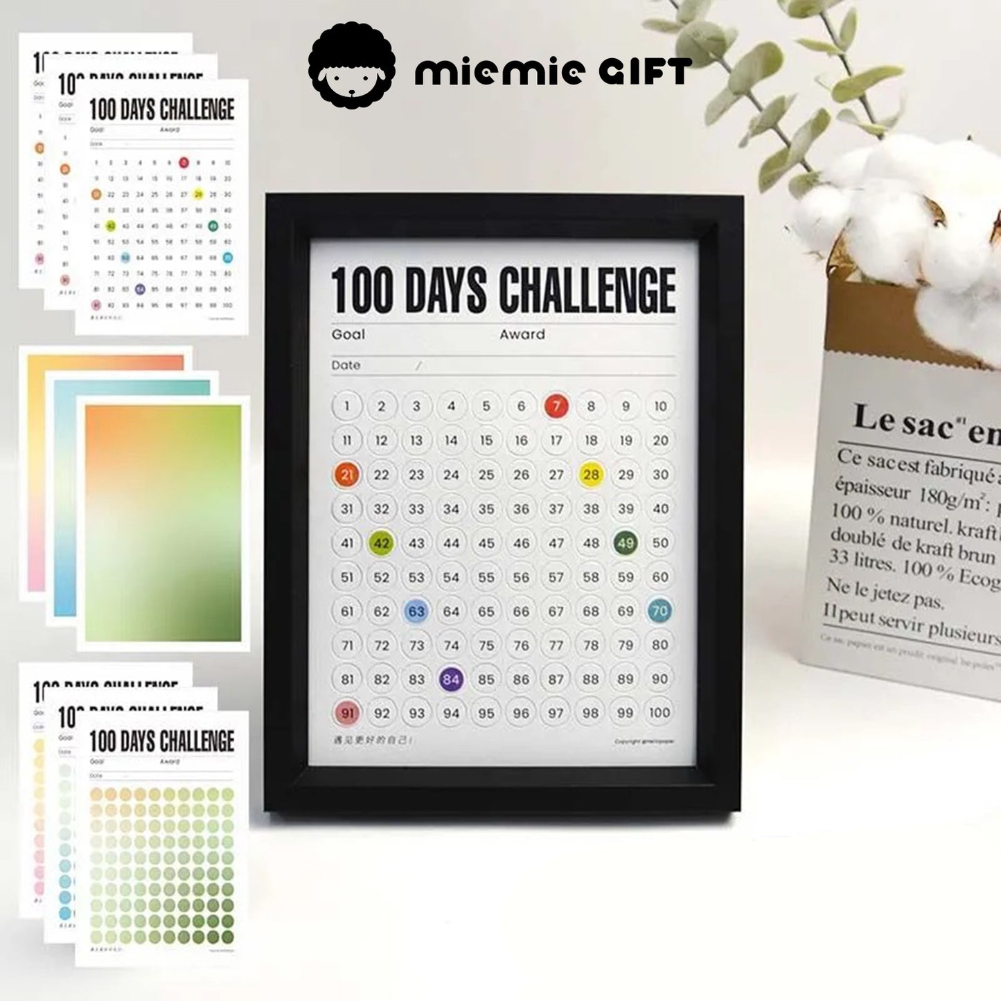 A black-framed 100 Days Challenge tracker surrounded by vibrant gradient paper options, including green, blue, and warm tones. The image highlights the customizable design and functionality, perfect for goal tracking and as a stylish decorative element.