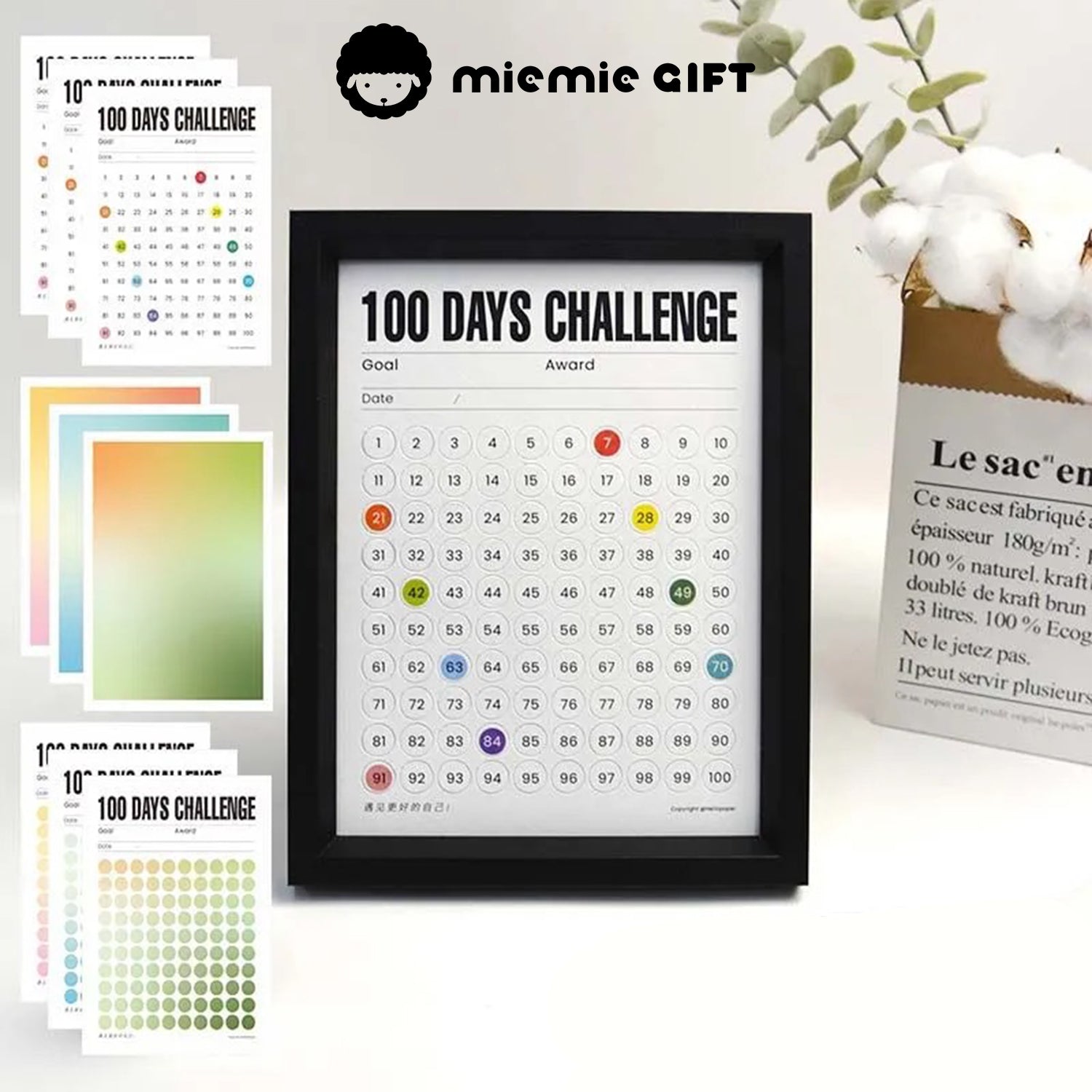 A black-framed 100 Days Challenge tracker surrounded by vibrant gradient paper options, including green, blue, and warm tones. The image highlights the customizable design and functionality, perfect for goal tracking and as a stylish decorative element.