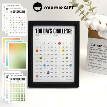 A black-framed 100 Days Challenge tracker surrounded by vibrant gradient paper options, including green, blue, and warm tones. The image highlights the customizable design and functionality, perfect for goal tracking and as a stylish decorative element.