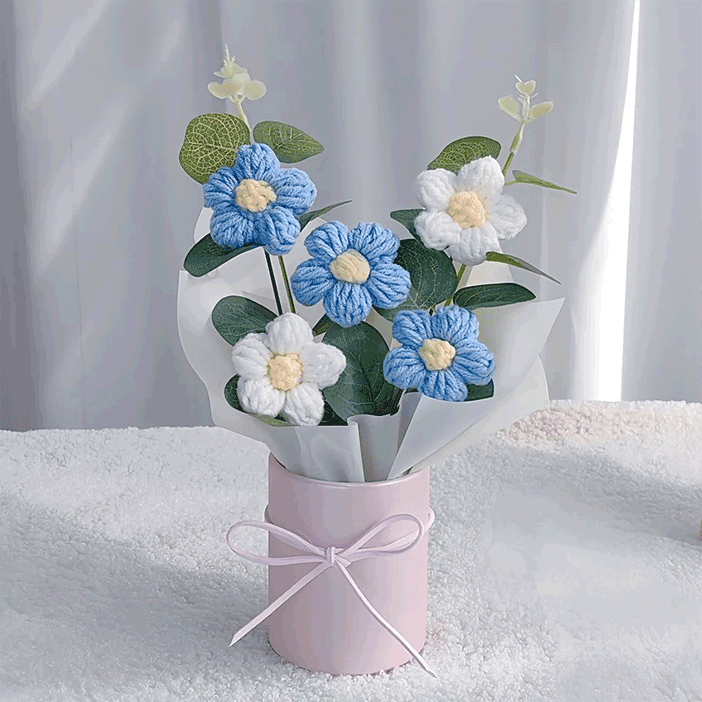 Hand-knitted blue Daisy Delight A bouquet of hand-knitted daisies a gift that blooms with love, elegantly arranged in a pink bucket with a bow