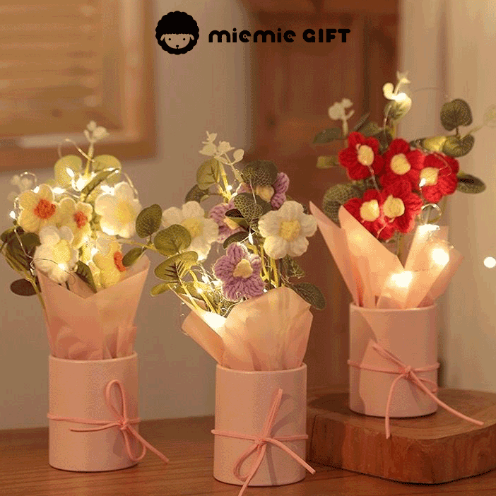 Knitted Daisy Serenity A bouquet of hand-knitted daisies a symbol of simplicity and grace arranged in a pink box with a bow and adorned with fairy lights for a touch of magic