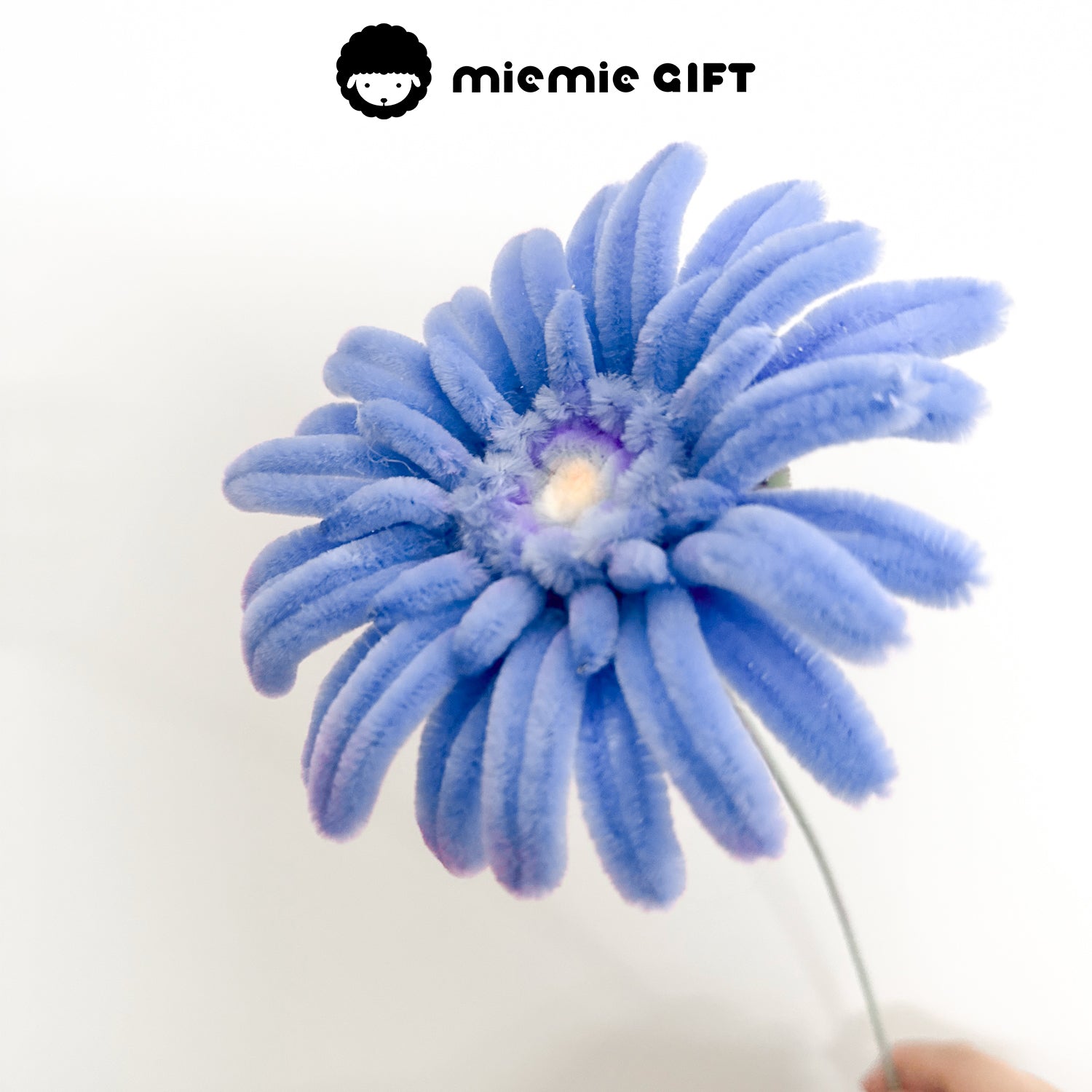 Close-up of a handmade blue frangipani flower crafted from pipe cleaners, adding a unique floral touch to any space.