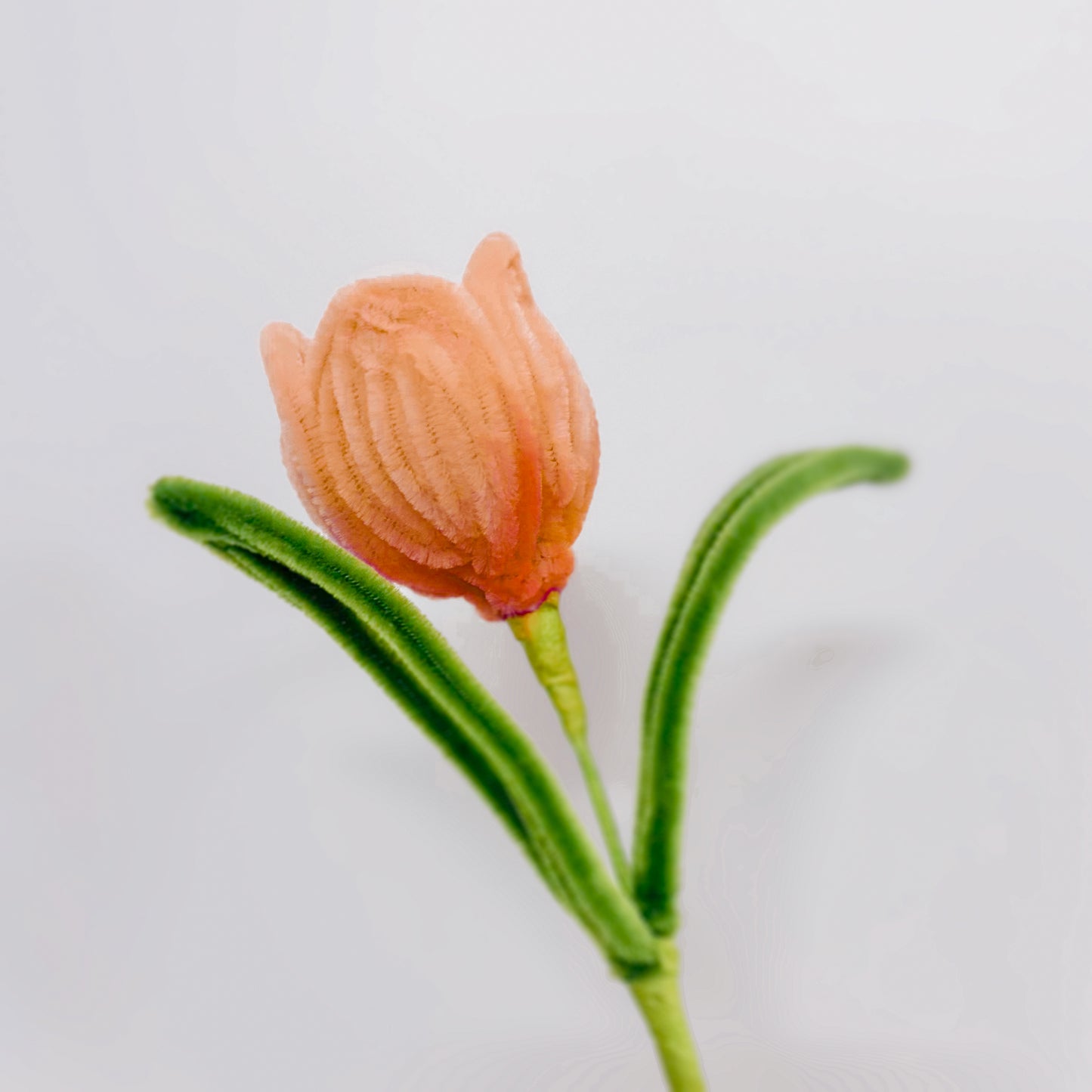 Handmade orange tulip flower with soft pipe cleaner petals and lifelike green leaves. A beautiful, long-lasting alternative to real flowers.
