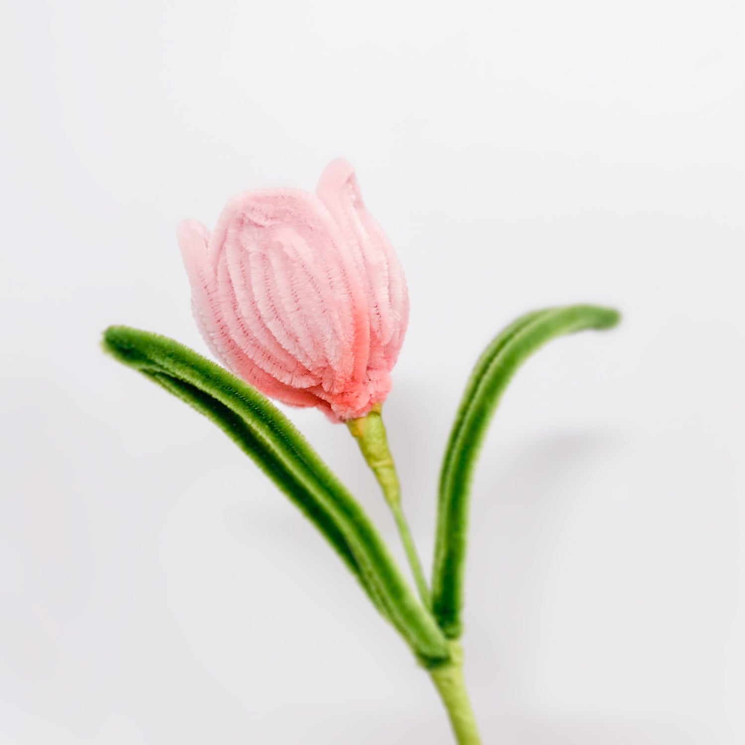 Handmade pink tulip made from premium pipe cleaners, featuring delicate petals and vibrant green leaves. Perfect for DIY crafts and floral arrangements