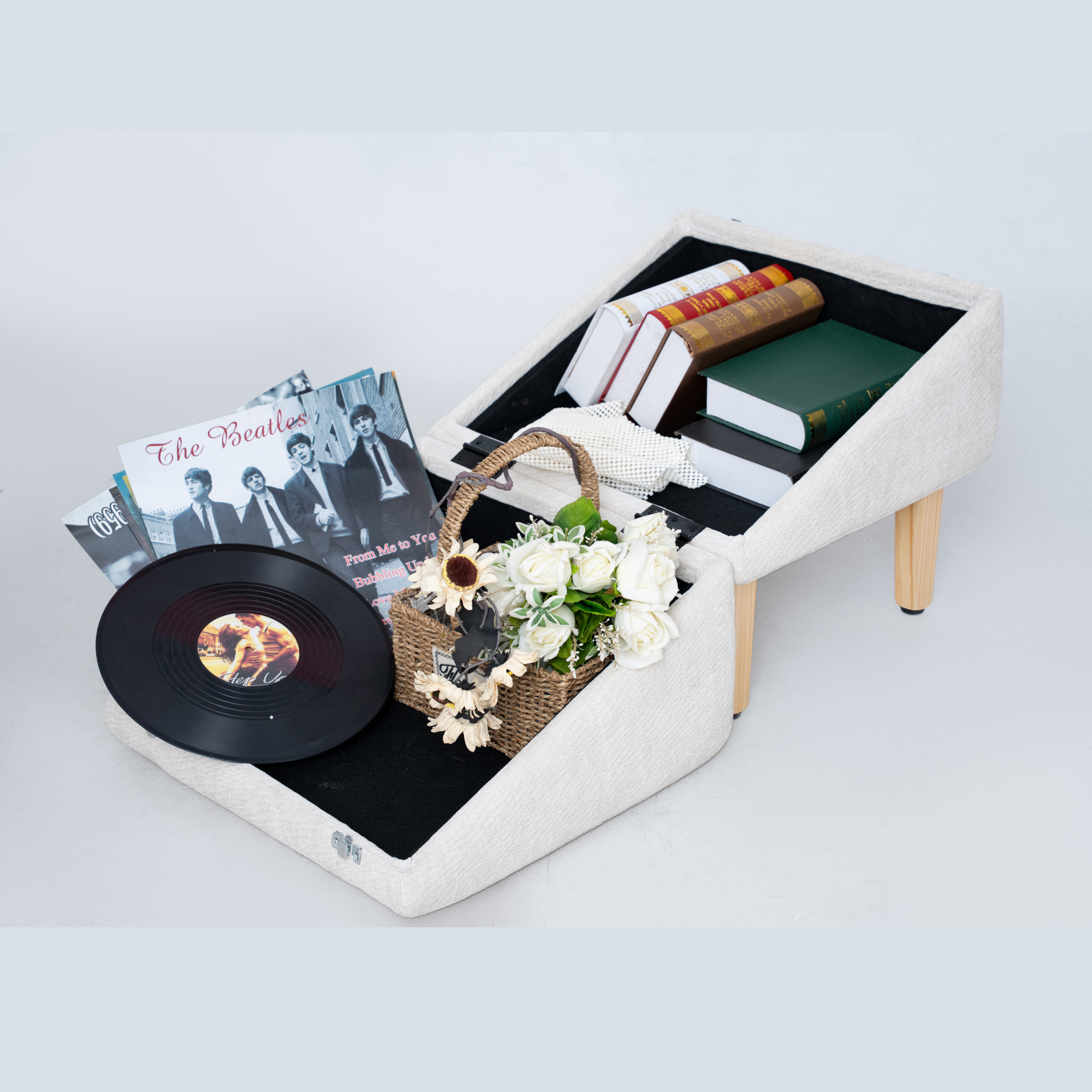 Beige MieMie’s Corner 3-in-1 pet ramp ottoman opened to show hidden storage, holding books, records, and decor; furniture-style ramp and seat for dogs.