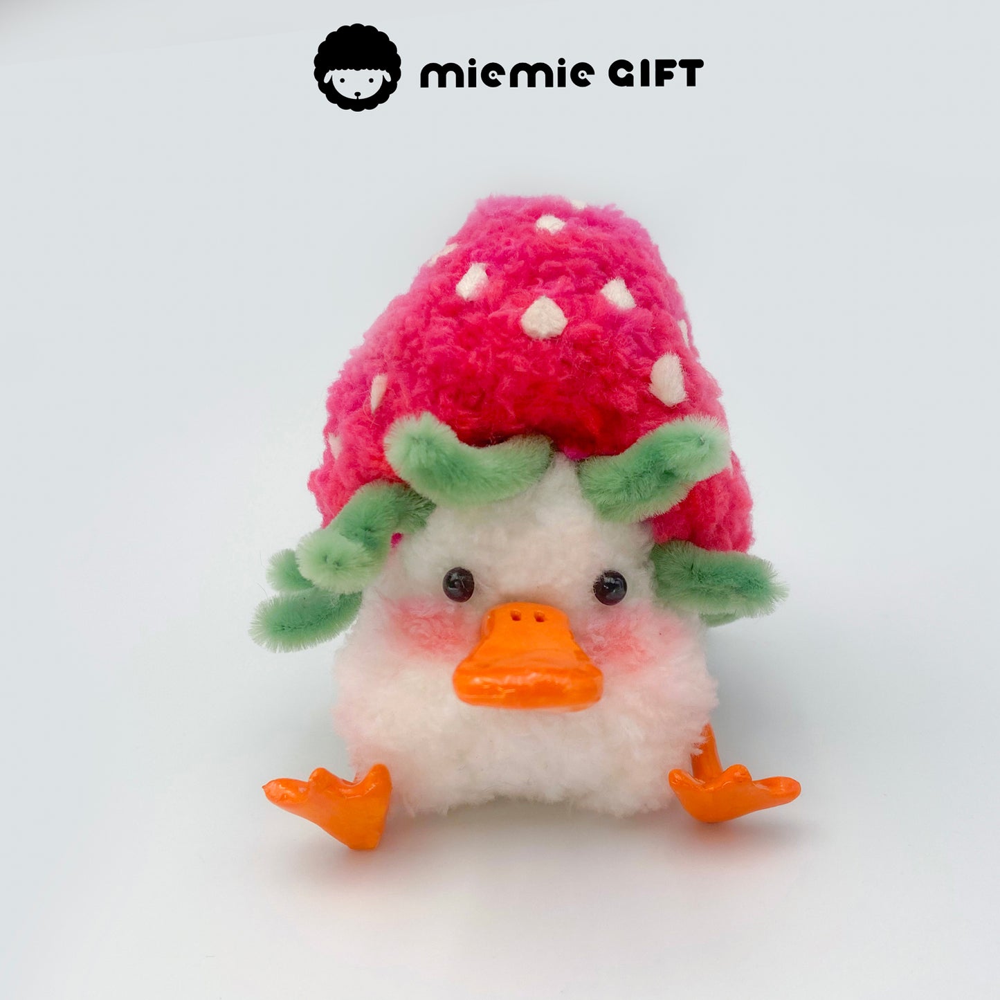 A fuzzy duck doll dressed like a strawberry, featuring yellow seed details and a leafy cap — soft and sweet by miemie gift.