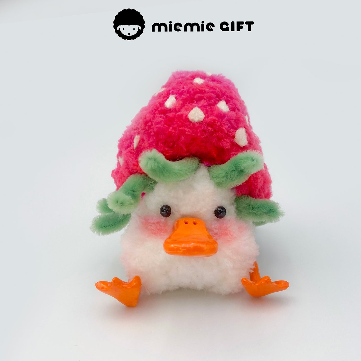 A fuzzy duck doll dressed like a strawberry, featuring yellow seed details and a leafy cap — soft and sweet by miemie gift.