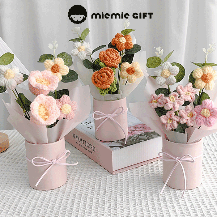 Three pastel pink mini flower buckets holding vibrant crocheted flowers, offering a unique handmade gift option