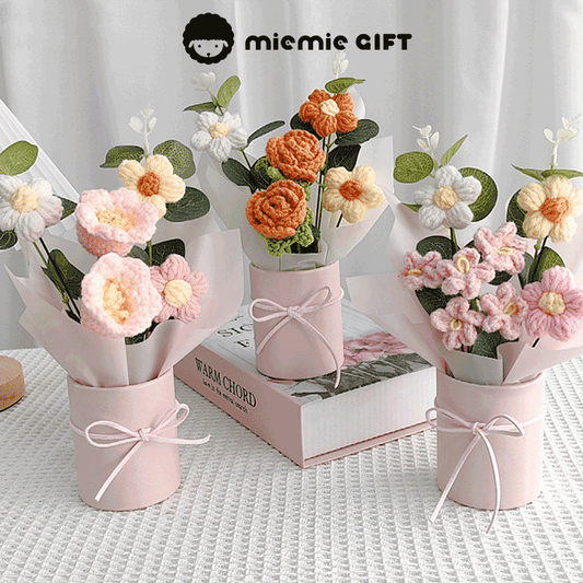 Three pastel pink mini flower buckets holding vibrant crocheted flowers, offering a unique handmade gift option