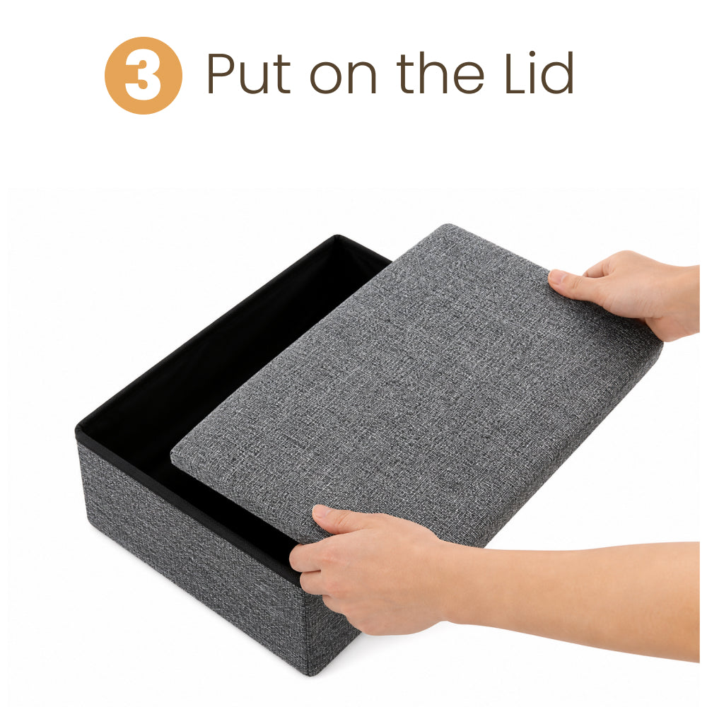 Assembly step 3: Hands place the padded fabric lid onto a gray storage box used as one section of the pet stairs.